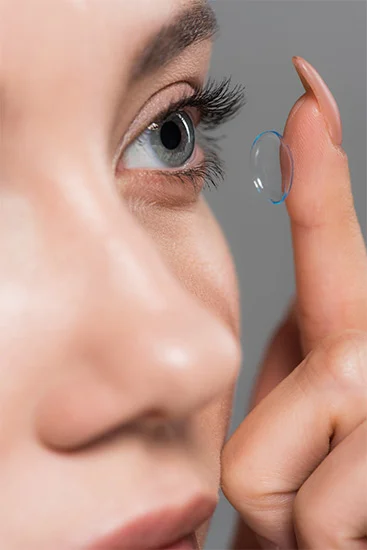 Close-up of a woman applying a contact lens at Cooper & Lourie Optometrists Nedlands.
