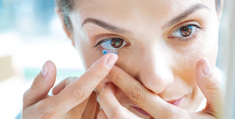 Woman applying a soft contact lens during a contact lens fitting and consultation